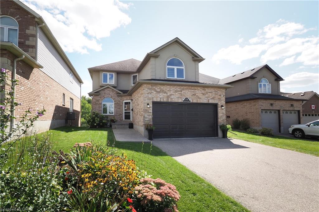Brick and stucco exterior with an attached two-car garage, arched window accents, and a concrete driveway