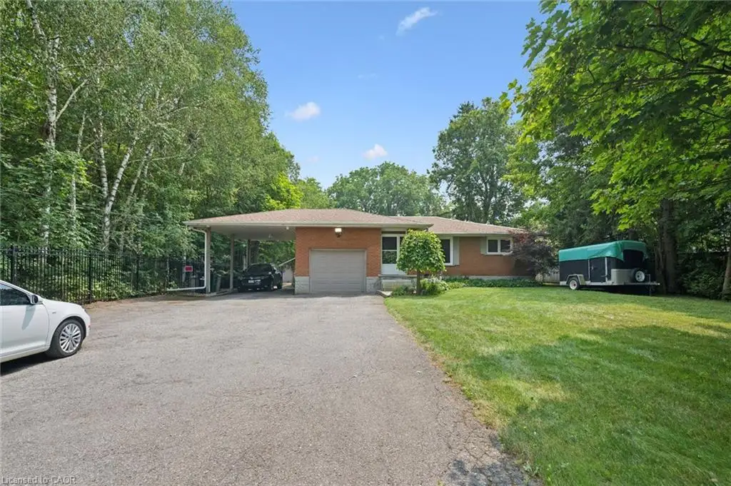 Brick exterior ranch-style residence featuring an attached single-car garage, a covered carport, and a spacious paved driveway