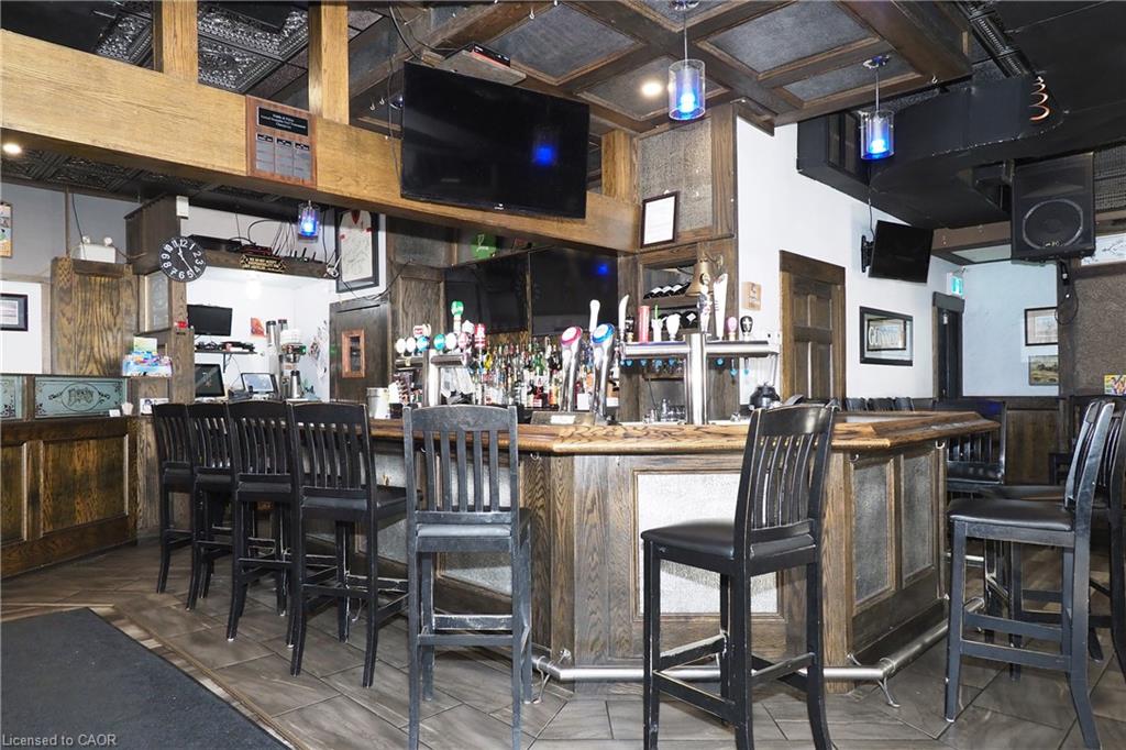Expansive bar area featuring a wood-finish bar top, integrated tap system, and decorative ceiling panels