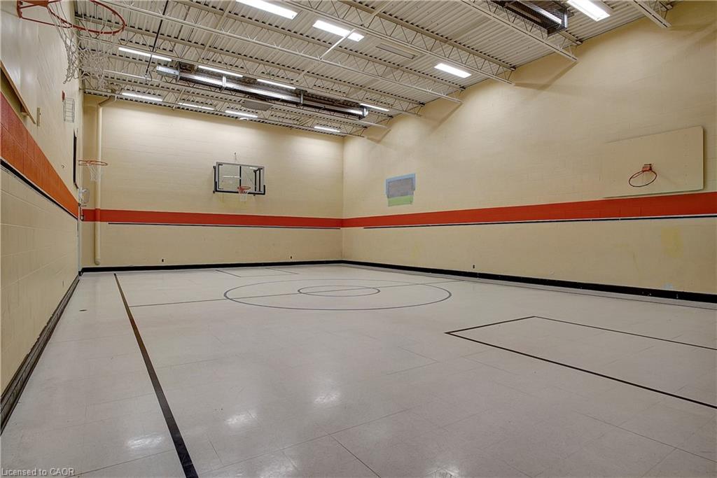 This property features a spacious indoor court with a light-colored floor, court lines, and multiple basketball hoops