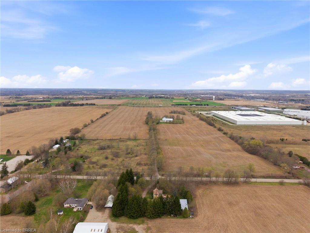 Expansive agricultural land featuring cleared fields and scattered mature trees