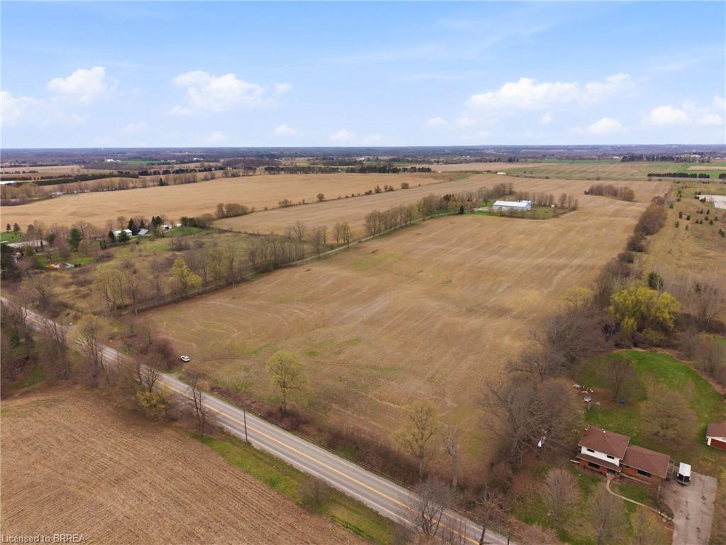Expansive land parcel featuring cultivated fields and scattered mature trees