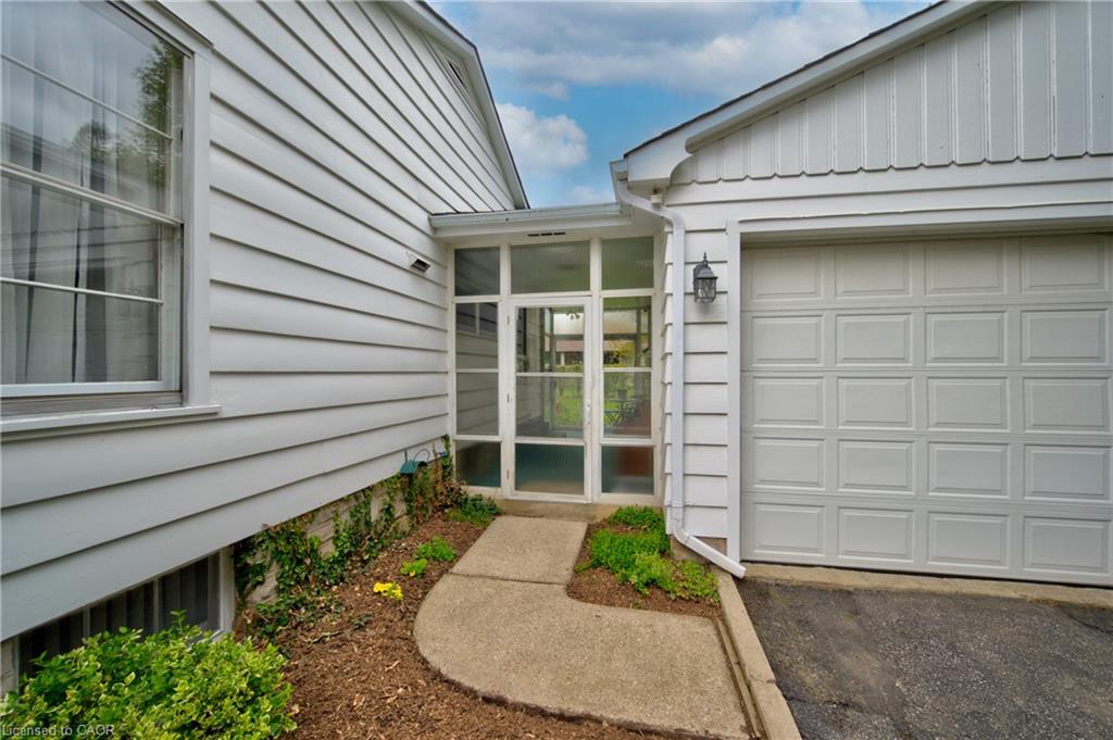 White Horizontal siding exterior with a screened-in entry, an attached garage, and a concrete pathway