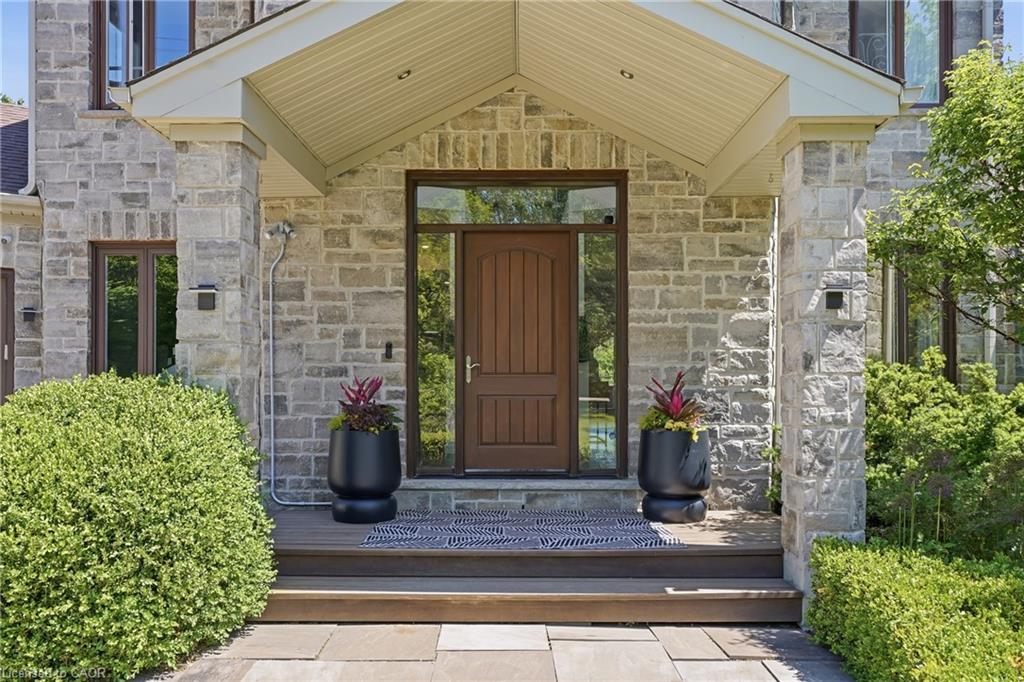 Stone facade with a covered entry, wood-finish door, and integrated sidelight windows
