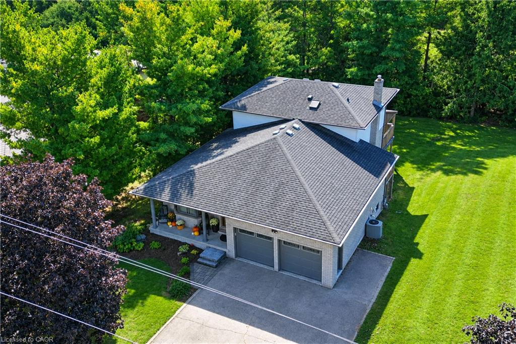 Two-car garage with gray doors, covered front porch, and a paved driveway