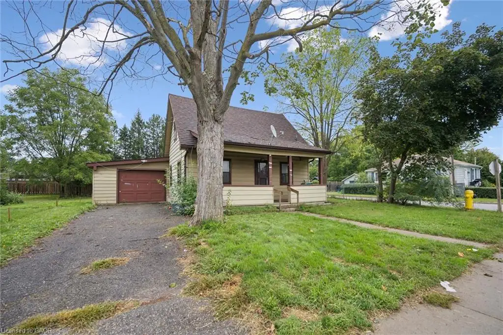 Single-story residence featuring a covered front porch, asphalt-paved driveway, attached garage, and exterior horizontal siding