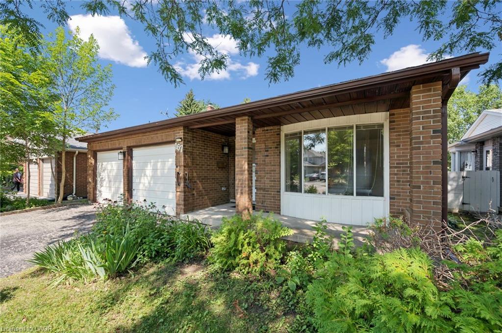 Brick exterior with an integrated two-car garage, covered porch, and a curved bay window