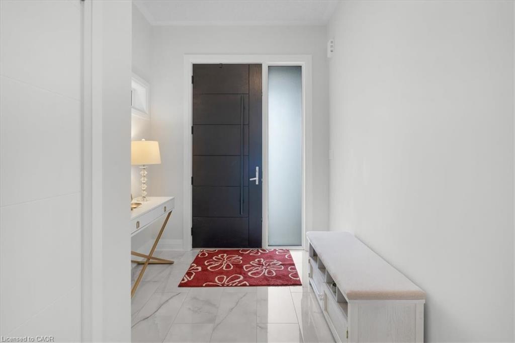 Entryway featuring a modern black paneled door with a frosted sidelight