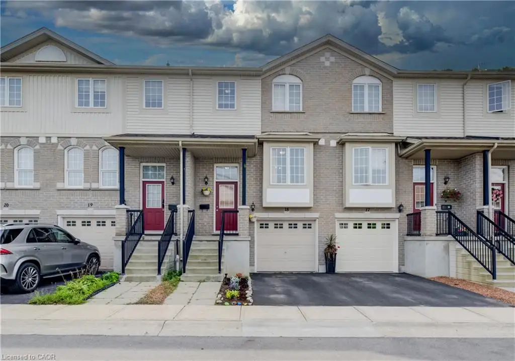 Brick and siding exterior with multiple bay windows, individual garages, and covered front entrances