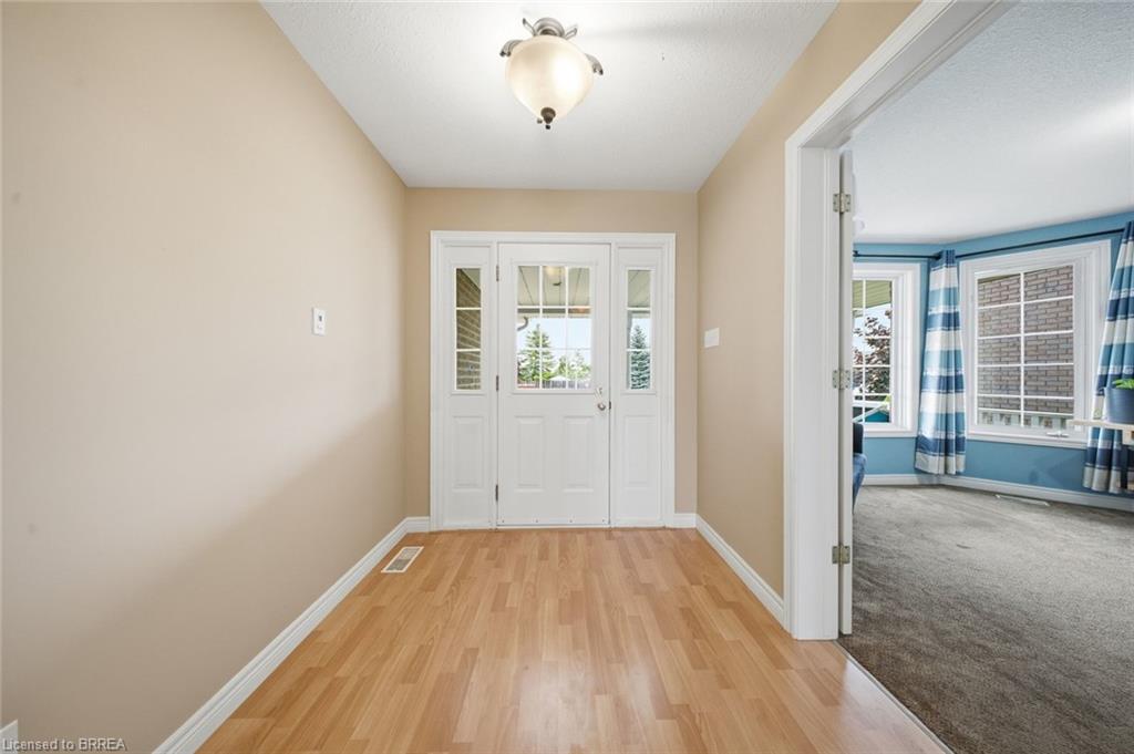 Entryway featuring wood-finish flooring and a white paneled door with glass inserts