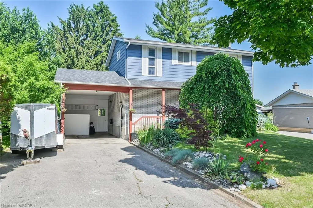 Traditional-style home with driveway, an attached carport, a front yard, and brick siding