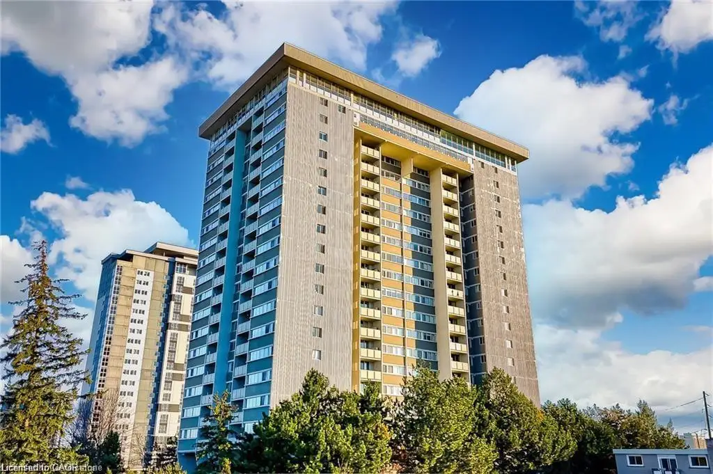 Modern high-rise residential building featuring multiple private balconies, a flat roofline, and a prominent blue and yellow facade