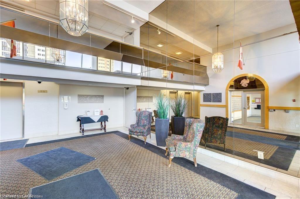 Spacious lobby with patterned carpet flooring, dual chandeliers, and an arched entry