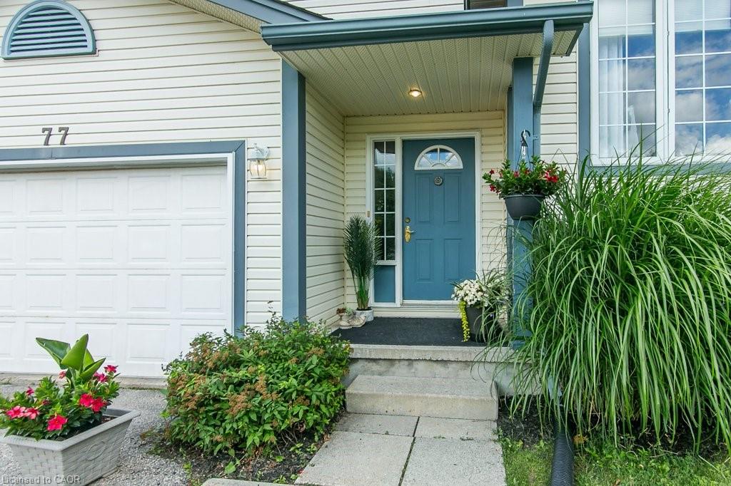 Entryway featuring a paneled door with an arched transom, covered porch, and exterior lighting