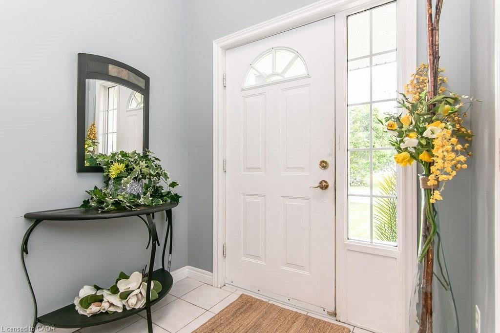 Entryway featuring a paneled front door with an arched transom window and a full-length sidelight