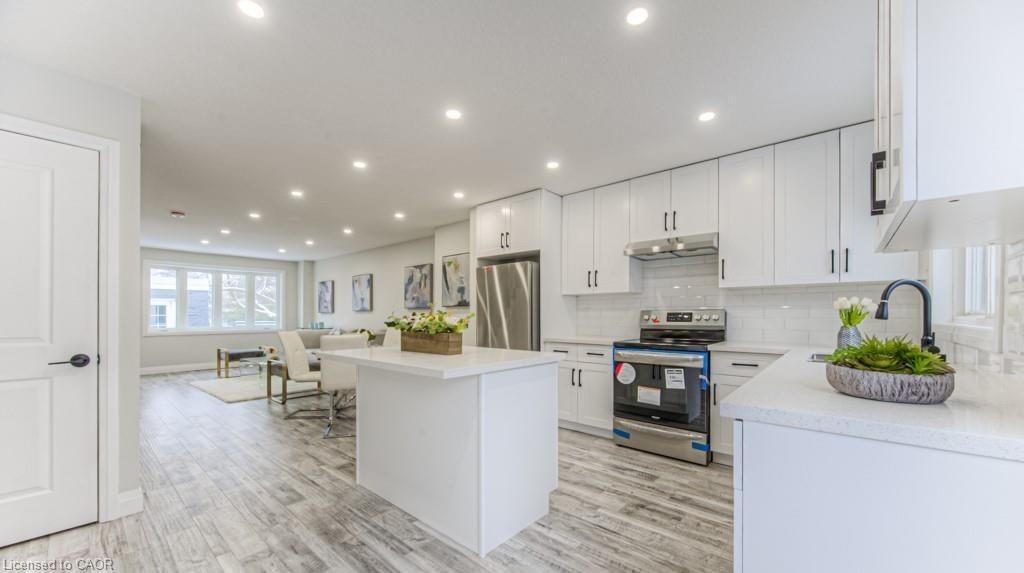 Open-concept living space with wood-finish flooring, recessed lighting, and a kitchen island