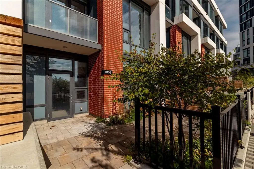 Modern building exterior featuring red brick, white facade accents, and a ground-level entrance with glass paneling
