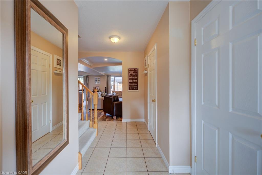Tiled entryway featuring a wood-framed mirror and arched doorway