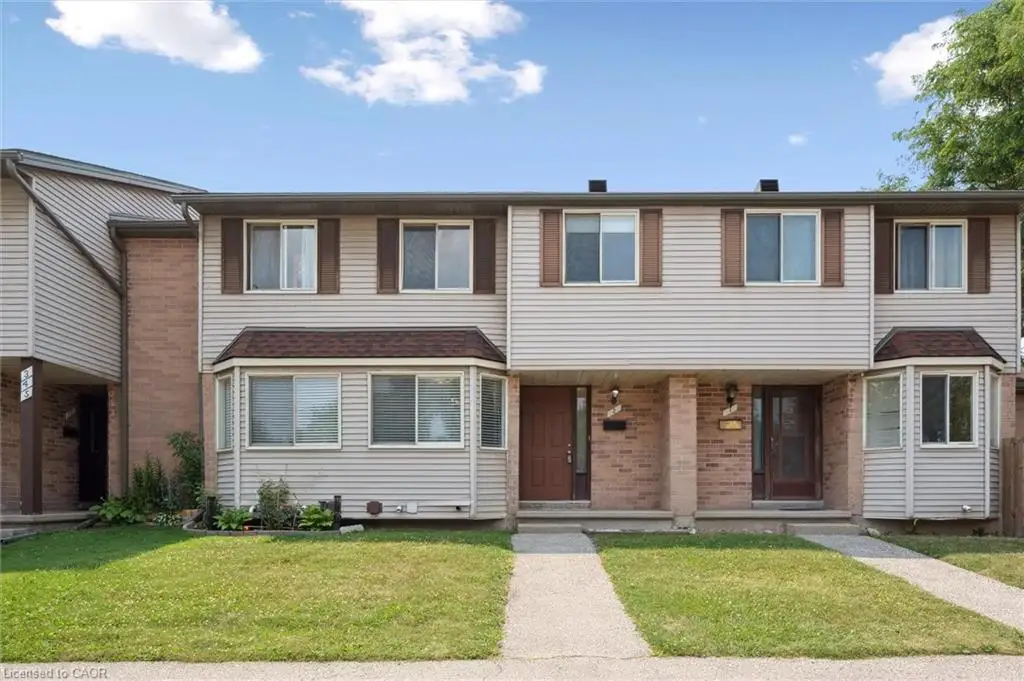Exterior featuring siding and brick accents, bay windows, and individual entry doors