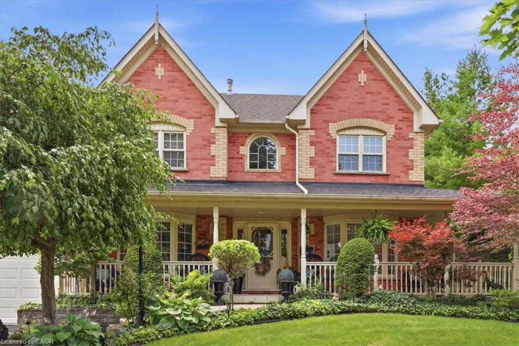 Red brick facade featuring gabled rooflines, contrasting brick accents, and a covered porch with white railings
