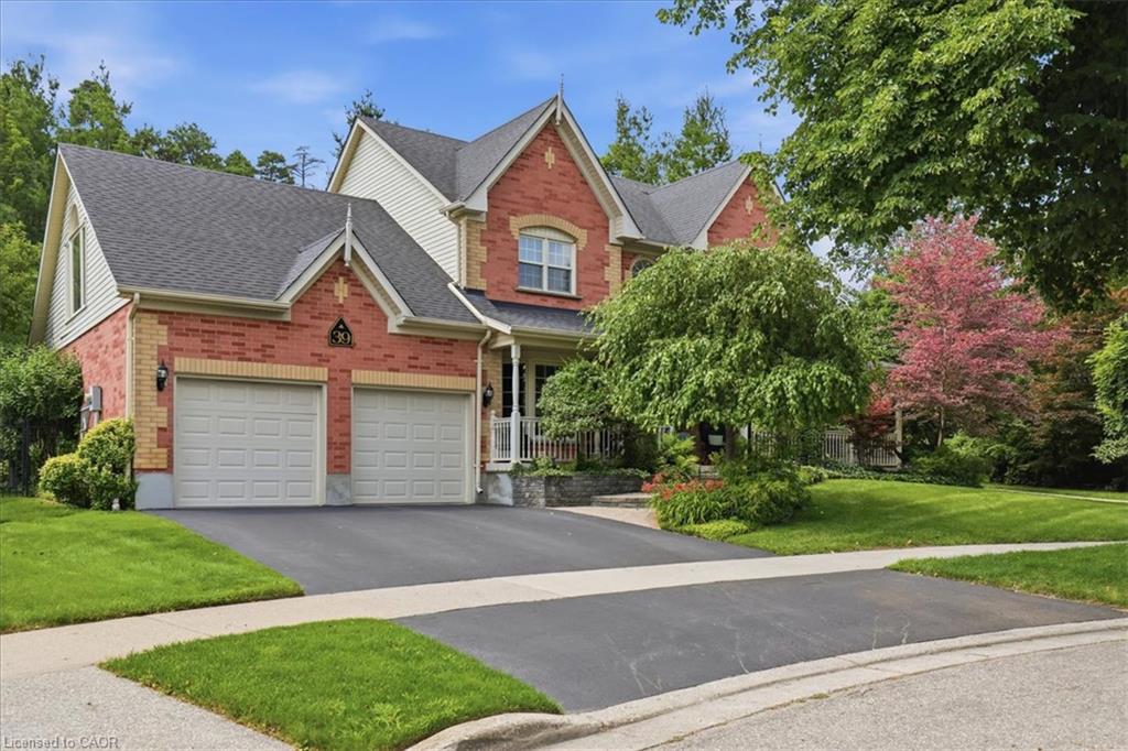 Brick and siding exterior featuring a multi-gabled roofline and a two-car garage