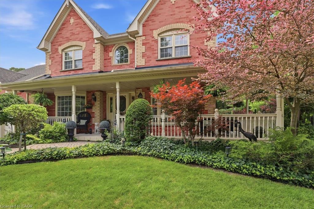 Brick facade residence featuring a covered front porch, white railing, and decorative arched window