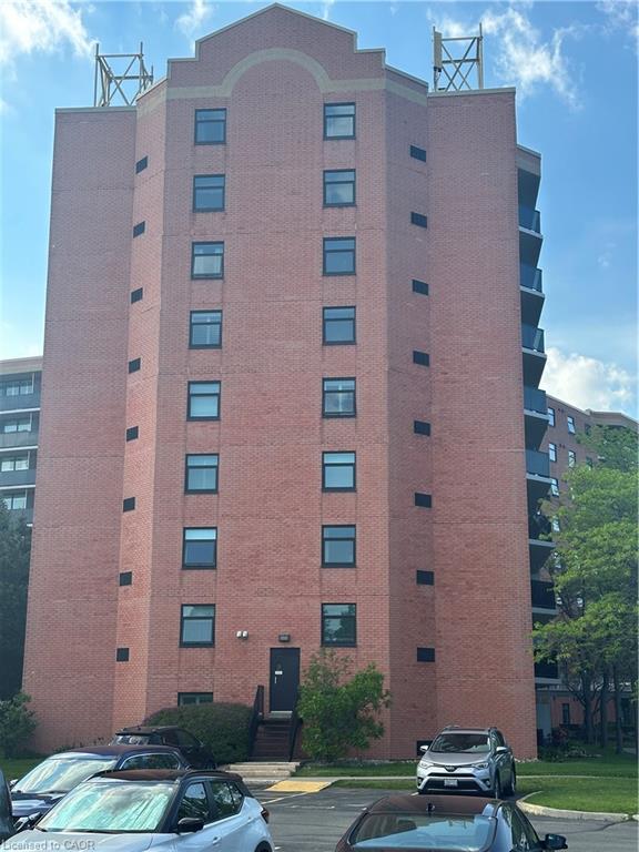 Multi-story brick building featuring a prominent gabled roofline with arched detailing