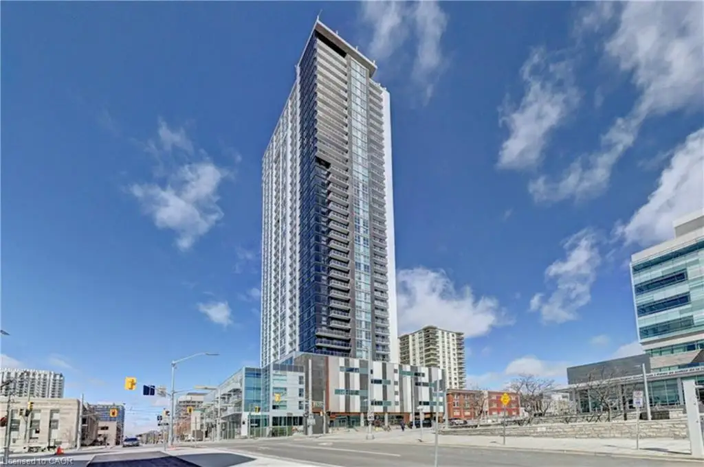 Modern high-rise building featuring a sleek glass facade and multiple balconies