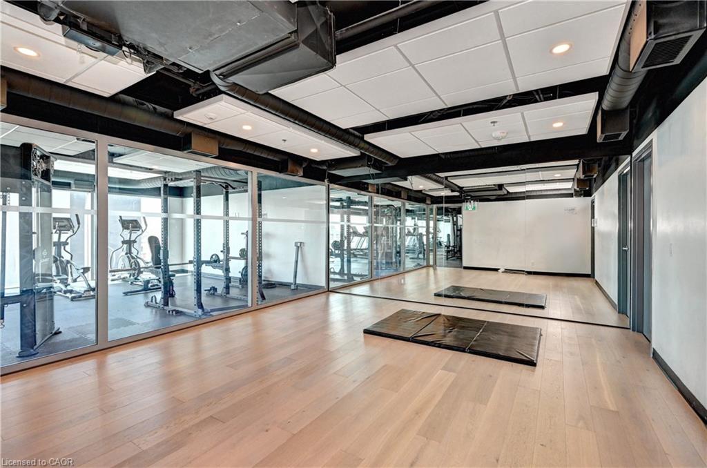 Wood-finish flooring, full-height wall mirrors, and recessed ceiling lighting