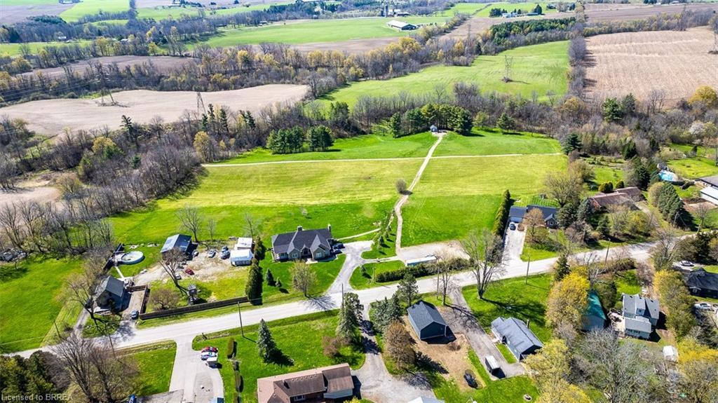 Expansive property featuring a large residence with a dark roof, multiple outbuildings, and extensive green space