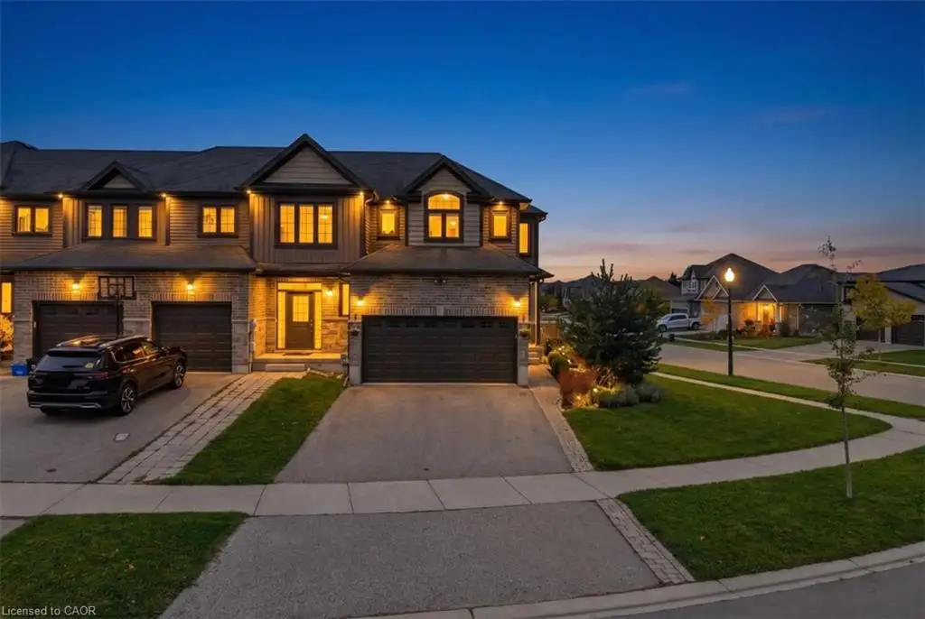 Multi-level exterior featuring a stone and horizontal siding facade, multiple peaked roof gables, two attached garages, and a paved driveway