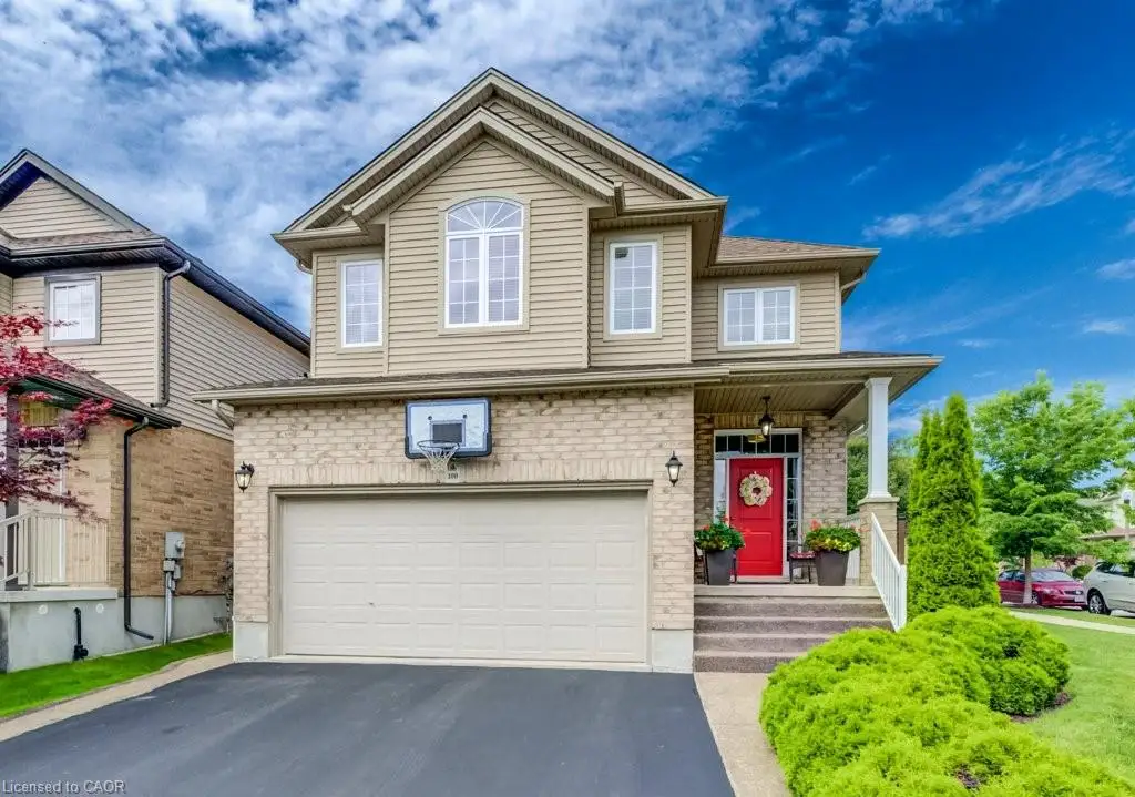 Two-story residential property featuring a brick and siding exterior, an attached two-car garage, a covered front porch with white columns, and a vibrant red entry door