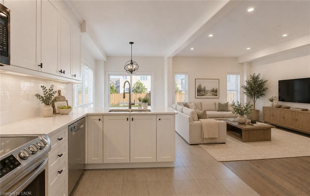 Open-concept kitchen and living area featuring white shaker cabinetry, stainless steel appliances, a white subway tile backsplash, and light-toned countertops