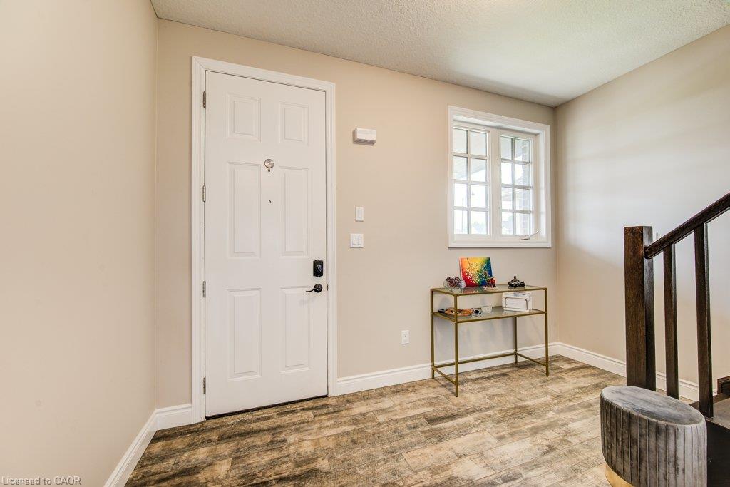 Entryway featuring wood-finish flooring, a white paneled door, and a multi-pane window