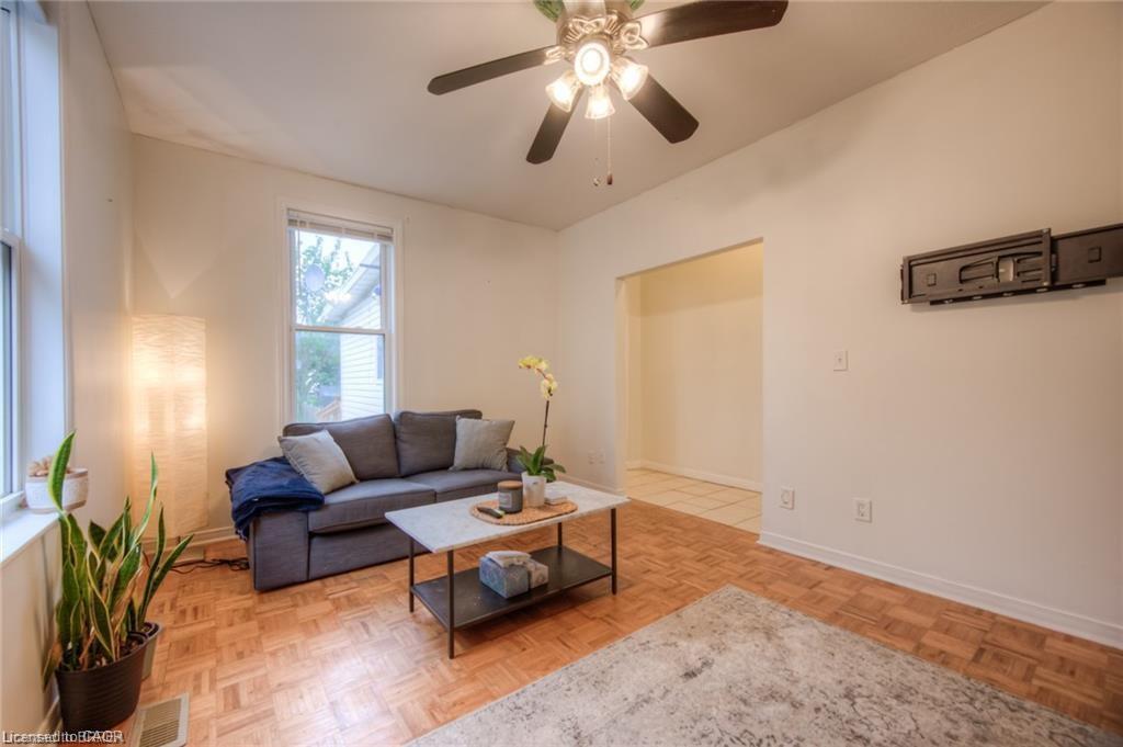 Living area with ceiling fan and parquet floors