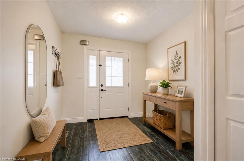 Foyer entrance featuring dark wood-finish flooring, a white paneled door with glass inserts, and light-toned walls