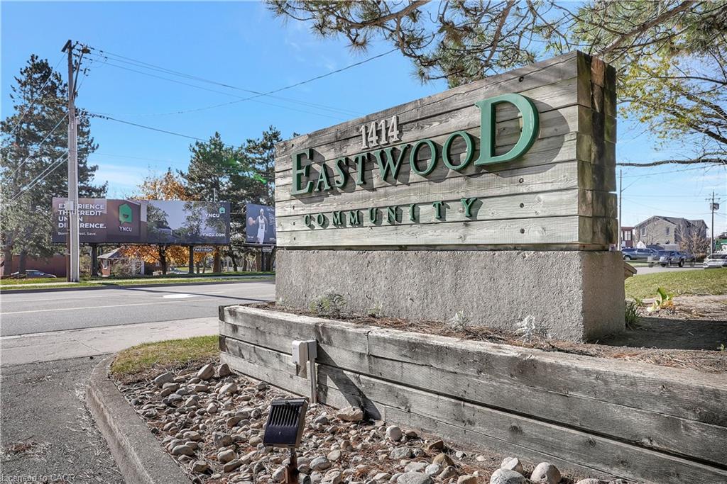 Wood-finish community signage with raised lettering and stone base