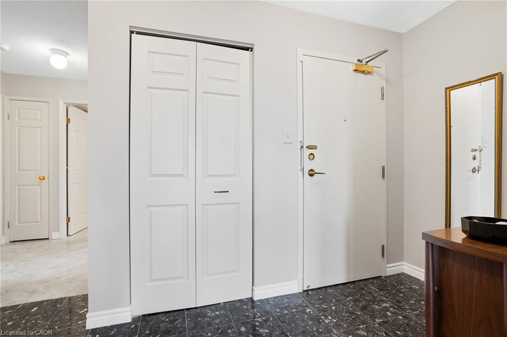 Entryway featuring dark patterned tile flooring, a white paneled bi-fold closet, and a light gray wall finish
