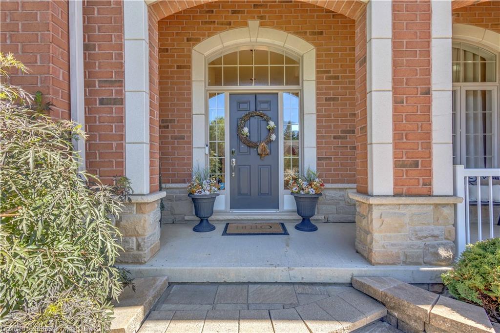 Brick exterior with stone accents, arched entryway, transom window, and paneled front door