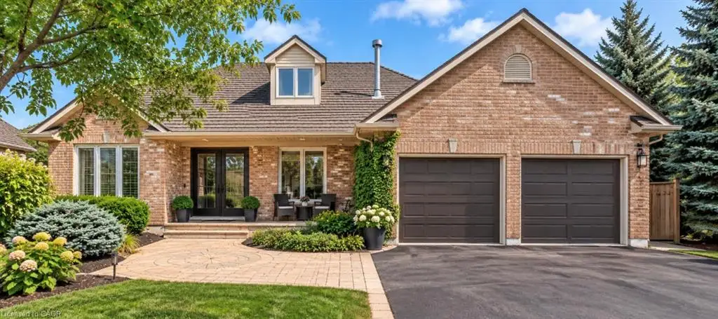 Brick exterior with a dormer window and dual garage doors