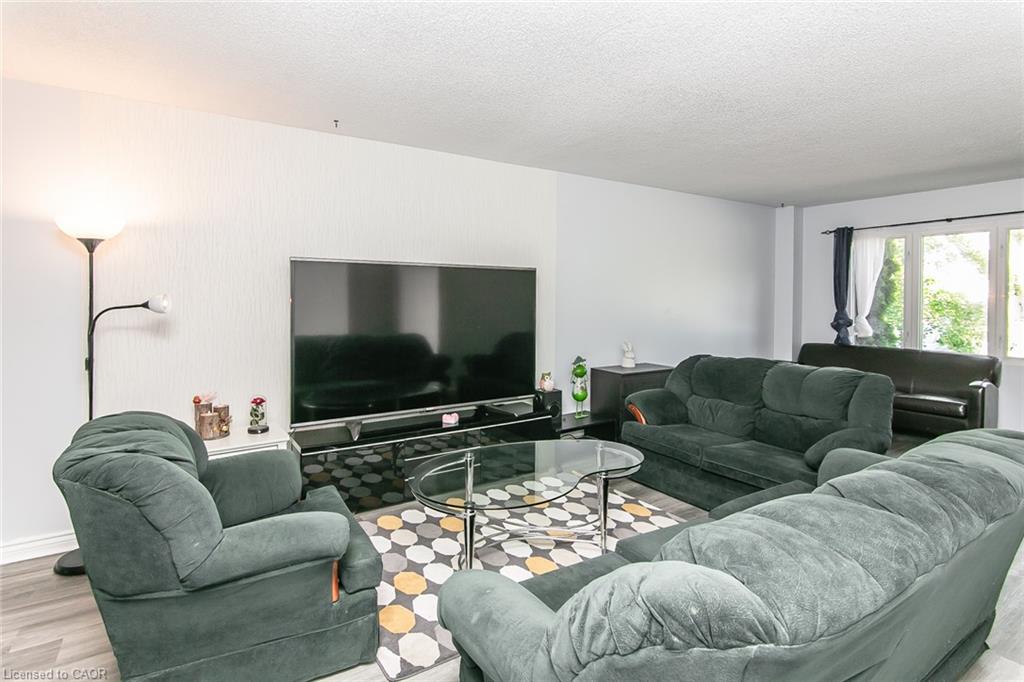 Expansive living area featuring light wood-finish flooring and large windows with white frames