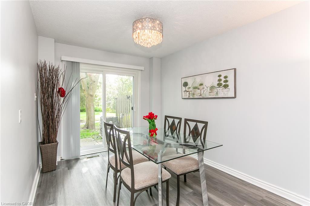 Sliding glass door leading to outdoor space, overhead chandelier, and wood-finish flooring