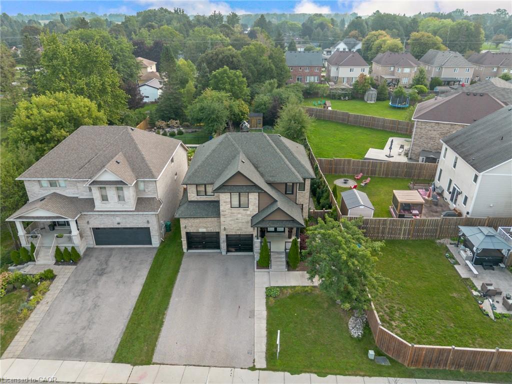 Contemporary home with stone and siding exterior, a two-car garage, and a paved driveway