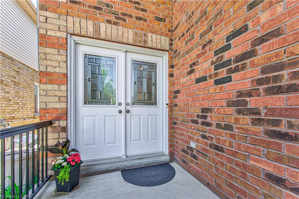 Brick exterior with white double entry doors featuring decorative glass inserts