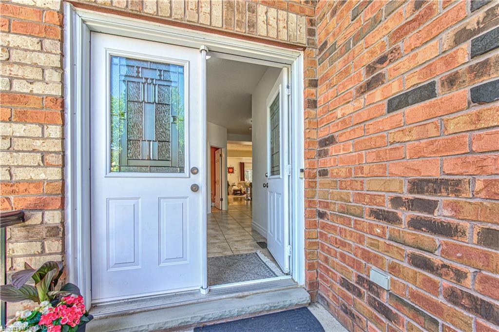 Brick exterior with a white entry door featuring decorative glass