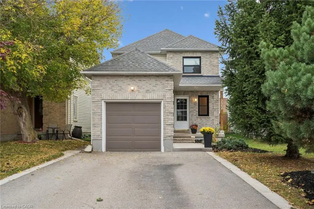 Two-story brick exterior featuring a shingled roof, attached single-car garage, and asphalt driveway