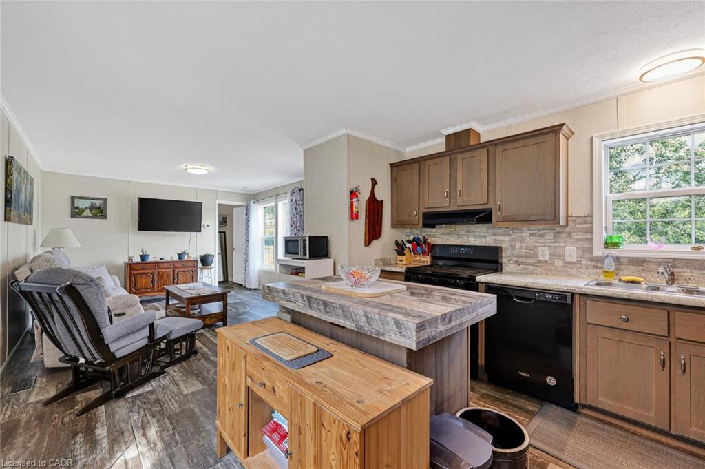 Kitchen featuring wood-finish cabinetry, stone-look countertops, and a tile backsplash