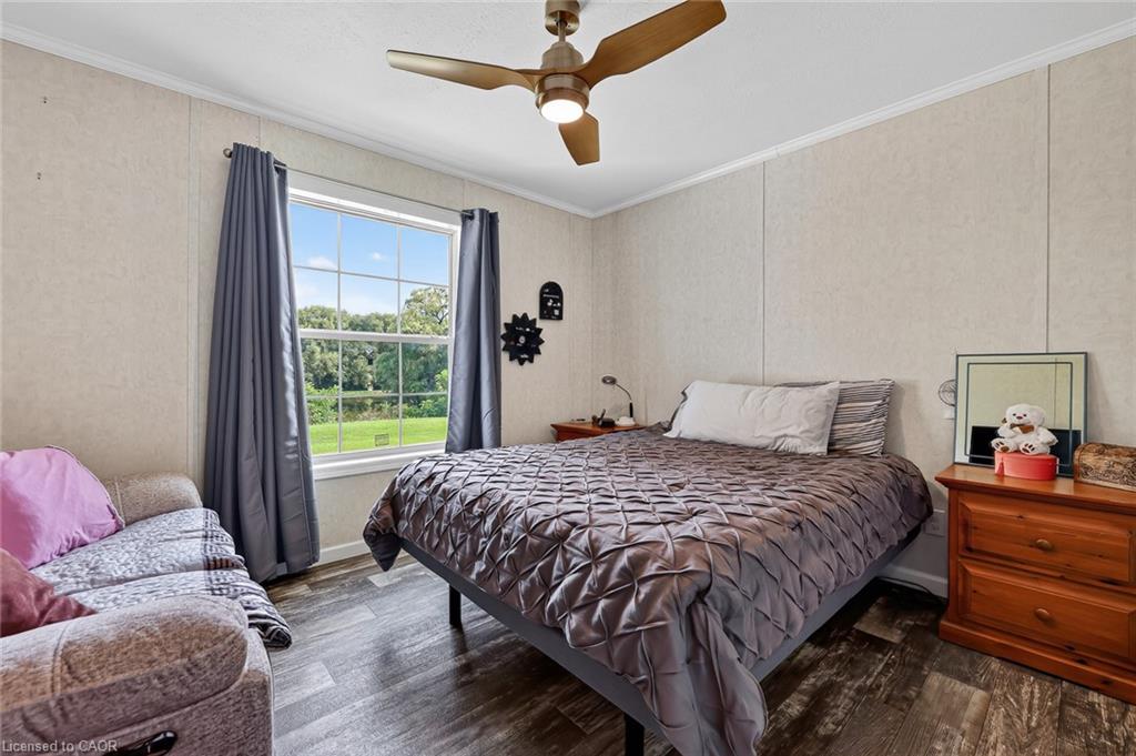 Wood-finish flooring with a ceiling fan and overhead lighting