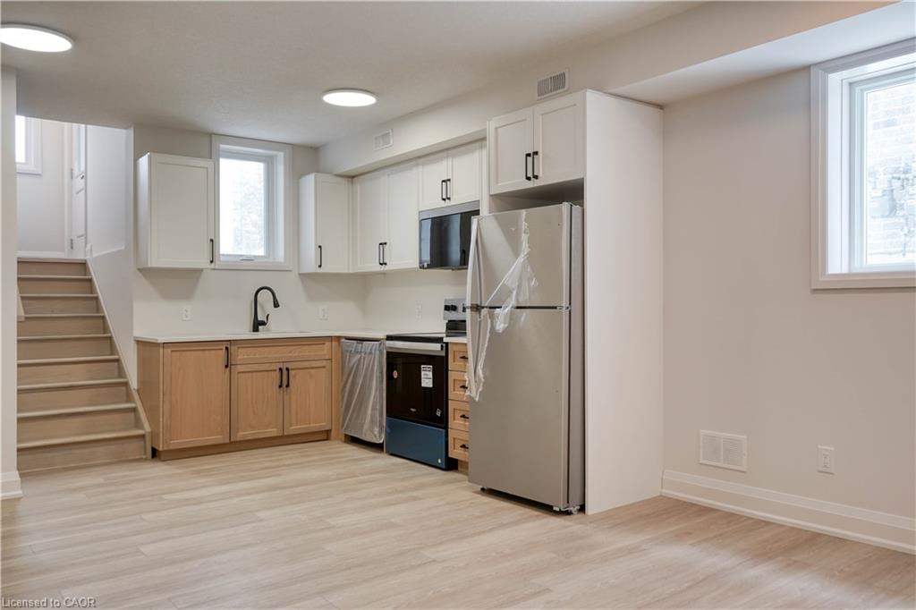Kitchen with appliances with stainless steel finishes, light wood-style flooring, healthy amount of natural light, and light countertops