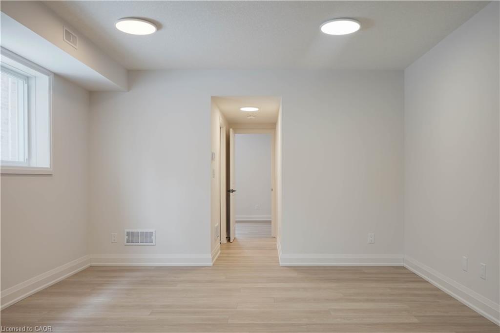 Unfurnished room with light wood-style floors and baseboards